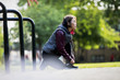 © Tom Merton/Caia Image - Active senior female runner with headphones tying shoe in park