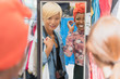 © Tom Merton/Caia Image - Young women friends shopping at mirror in clothing store