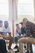 © Tom Merton/Caia Image - Men with digital tablet talking in group therapy circle