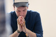 © Tom Merton/Caia Image - Man praying with rosary