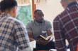 © Tom Merton/Caia Image - Attentive young man with bible in prayer group