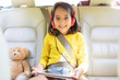 © Sam Edwards/Caia Image - Portrait smiling, confident girl watching movie headphones digital tablet in back seat of car
