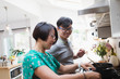 © Sam Edwards/Caia Image - Couple cooking at kitchen stove