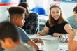 © Paul Bradbury/Caia Image - Smiling high school girl student talking with classmates in classroom