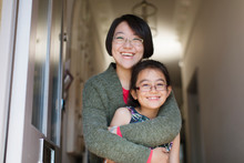 Portrait Happy, Affectionate Mother And Daughter Hugging In Doorway