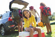 © Sam Edwards/Caia Image - Portrait smiling girl camping with family, unloading car