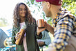 © Sam Edwards/Caia Image - Daughter pouring coffee from insulated drink container fro father at campsite