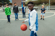 © Paul Bradbury/Caia Image - Portrait confident tween boy playing basketball in schoolyard