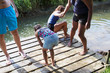 © Sam Edwards/Caia Image - Family swimming, playing on riverside dock