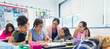 © Robert Daly/Caia Image - Female teacher junior high school girl students at desk in classroom
