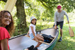 © Sam Edwards/Caia Image - Family carrying canoe in woods