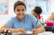 © Robert Daly/Caia Image - Portrait confident junior high school boy student doing homework in classroom