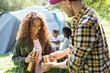 © Sam Edwards/Caia Image - Daughter pouring coffee from insulated drink container for father at campsite