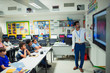 © Paul Bradbury/Caia Image - Male teacher leading lesson at touch screen in classroom