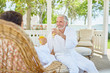 © Trevor Adeline/Caia Image - Mature couple in spa bathrobes drinking mimosas in resort gazebo