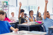© Robert Daly/Caia Image - Junior high school students with hands raised in classroom