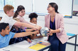 © Robert Daly/Caia Image - Eager students touching globe in geography teachers hands