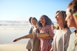 © Trevor Adeline/Caia Image - Happy friends with yoga mats on sunny beach during yoga retreat