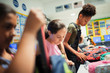 © Paul Bradbury/Caia Image - Junior high school girl students with backpacks in classroom