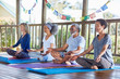 © Trevor Adeline/Caia Image - Serene people meditating in hut during yoga retreat