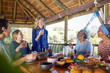 © Trevor Adeline/Caia Image - Friends enjoying healthy meal in hut during yoga retreat