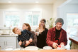 © Jarusha Brown/Caia Image - Portrait happy, playful family baking in kitchen
