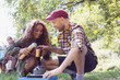 © Sam Edwards/Caia Image - Daughter pouring coffee from insulated drink container for father at camping stove