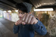 © Tom Merton/Caia Image - Portrait tough young man punching in urban tunnel