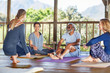 © Trevor Adeline/Caia Image - Yoga class talking in hut during yoga retreat
