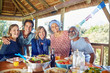 © Trevor Adeline/Caia Image - Portrait happy friends enjoying healthy meal in hut during yoga retreat