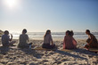 © Trevor Adeline/Caia Image - Yoga class talking on sunny beach during yoga retreat