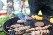 © Sam Edwards/Caia Image - Man barbecuing hamburgers, kebabs and corn cobs