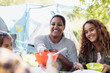 © Sam Edwards/Caia Image - Smiling mother and daughters enjoying lunch at campsite