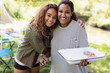© Sam Edwards/Caia Image - Portrait affectionate mother and daughter barbecuing at campsite