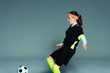 © Paul Bradbury/Caia Image - Teenage girl soccer player kicking soccer ball