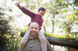 © Tom Merton/Caia Image - Portrait playful father carrying son on shoulders in park