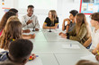 © Chris Ryan/Caia Image - High school students talking at table in debate class
