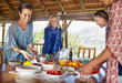 © Trevor Adeline/Caia Image - Friends enjoying healthy meal during yoga retreat in hut