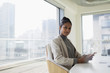 © Tom Merton/Caia Image - Portrait confident businesswoman using smart phone in urban conference room