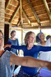 © Trevor Adeline/Caia Image - Confident woman practicing warrior 2 pose in hut during yoga retreat