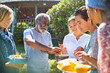 © Trevor Adeline/Caia Image - Friends enjoying healthy food outside sunny hut during yoga retreat