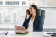 © Tom Merton/Caia Image - Smiling businesswoman talking on smart phone in office