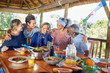 © Trevor Adeline/Caia Image - Happy friends hugging, enjoying healthy meal in hut during yoga retreat