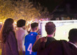 © Paul Bradbury/Caia Image - Friends watching soccer match on projection screen in backyard