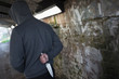 © Tom Merton/Caia Image - Dangerous man with knife behind back in urban tunnel
