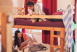 © Trevor Adeline/Caia Image - Young female backpackers on bunk bed in youth hostel