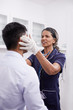 © Trevor Adeline/Caia Image - Female doctor examining male patient in clinic examination room