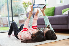 Girls Taking Selfie With Digital Tablet On Living Room Floor