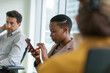 © Tom Merton/Caia Image - Businesswoman using smart phone in conference room meeting