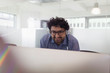© Tom Merton/Caia Image - Smiling businessman with headphones working at computer in office